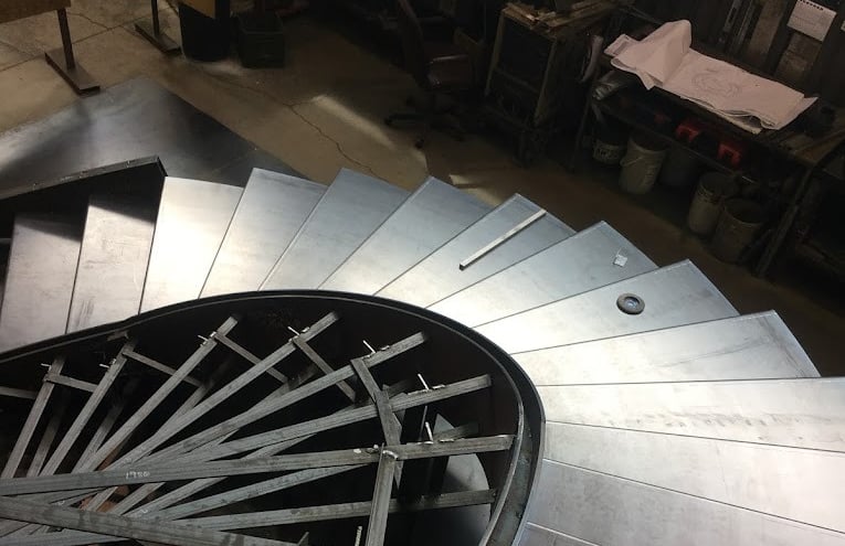 Metal eliptical stairs during installation, by Pengelly Iron Works