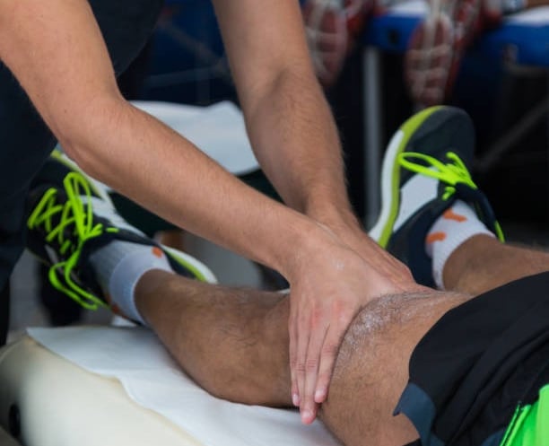 joven deportista recibiendo una terapia de descarga muscular después de una carrera