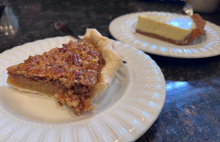A slice of homemade pecan pie served on white plates.