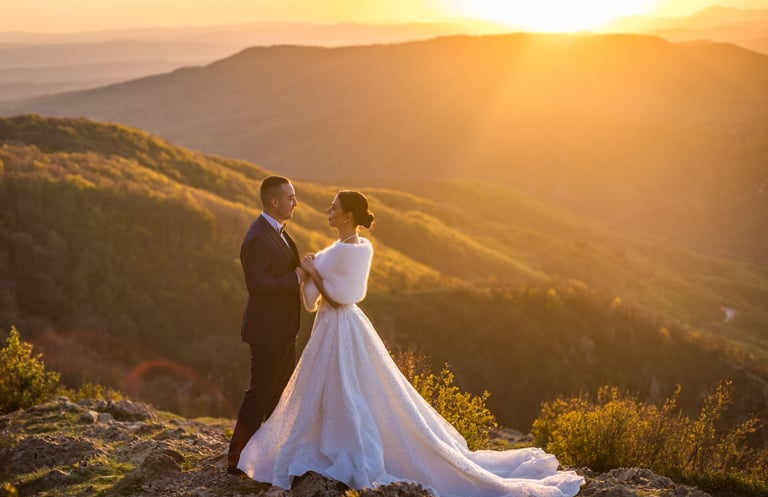 a bride and groom standing on a mountain top