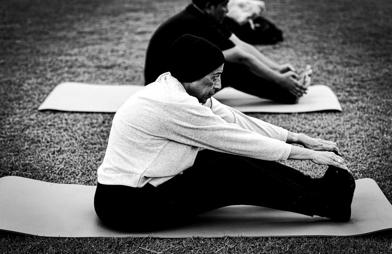 A man and woman doing outdoor yoga on a mat. Photo @hazmiljapilus / @jetpacklangkawi