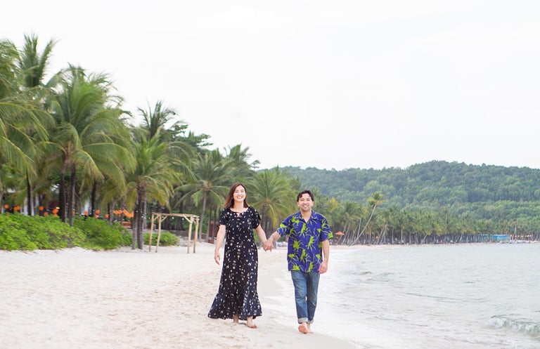 Couple walking hand in hand along Khem Beach