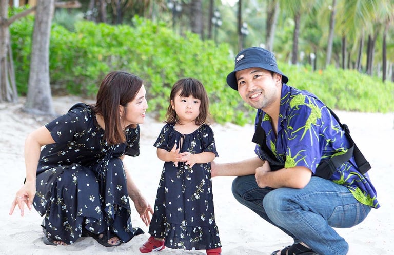 Family posing with child on Khem Beach in Phu Quoc