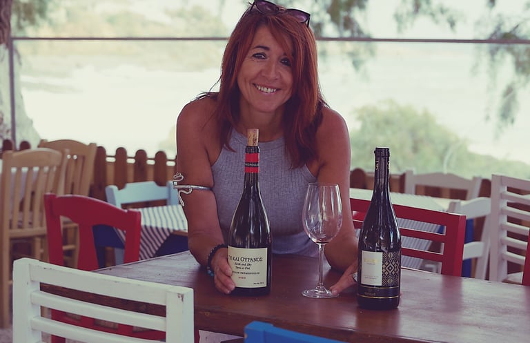 a sommeliere sitting at a table with wine glasses and greek bottles of wine in chania