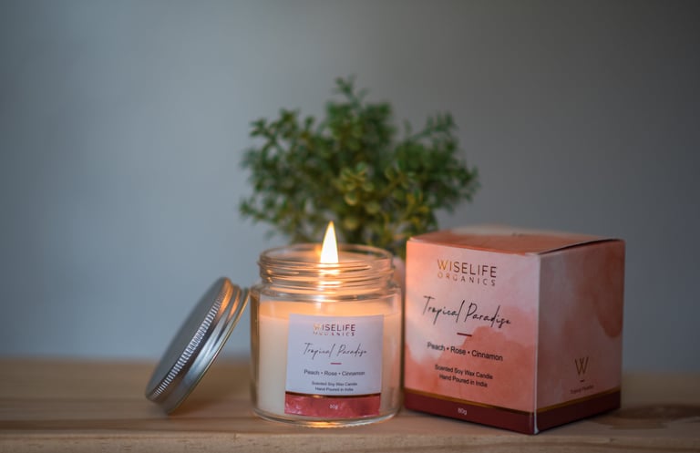 A Wiselife Organics "Tropical Paradise" scented candle, featuring peach, rose, and cinnamon notes