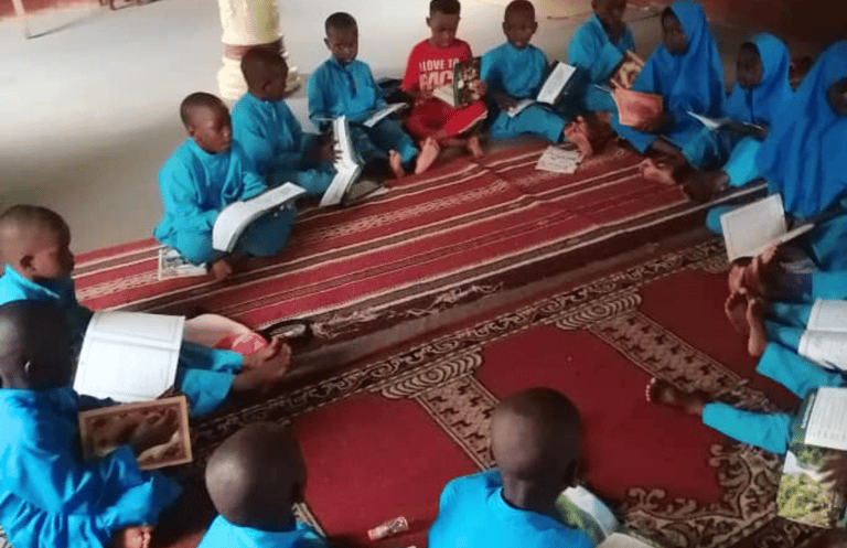 a group of children sitting on a rug in a room