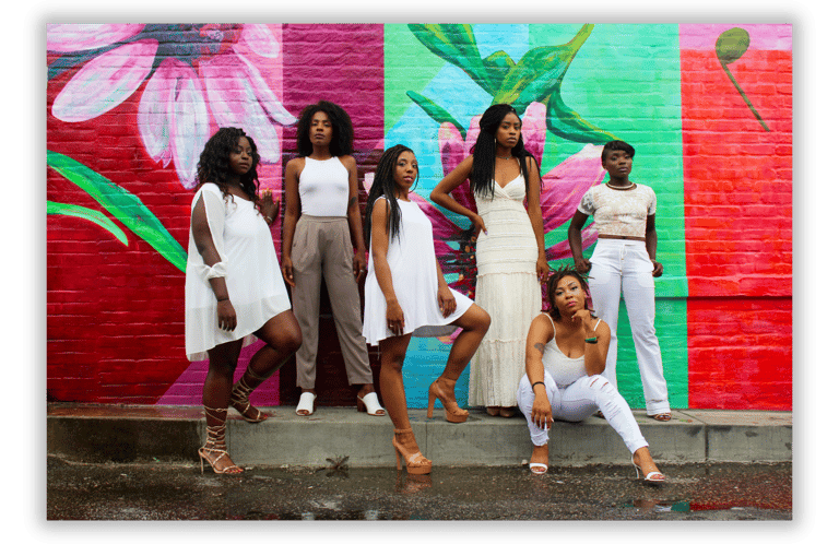Black women standing in unity against a colorful mural, representing sisterhood, empowerment....