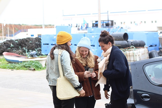 three women standing in front of a car