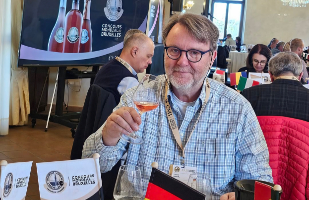 A wine judge holding a glass of rosé at the Concours Mondial de Bruxelles international competition.