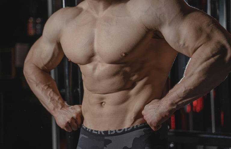  Homem musculoso exibindo abdômen definido e braços fortes em pose de treino.