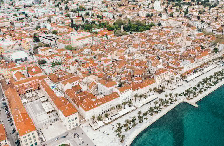 Aerial view of Split, Croatia, showing old town terracotta roofs and the Riva waterfront promenade.