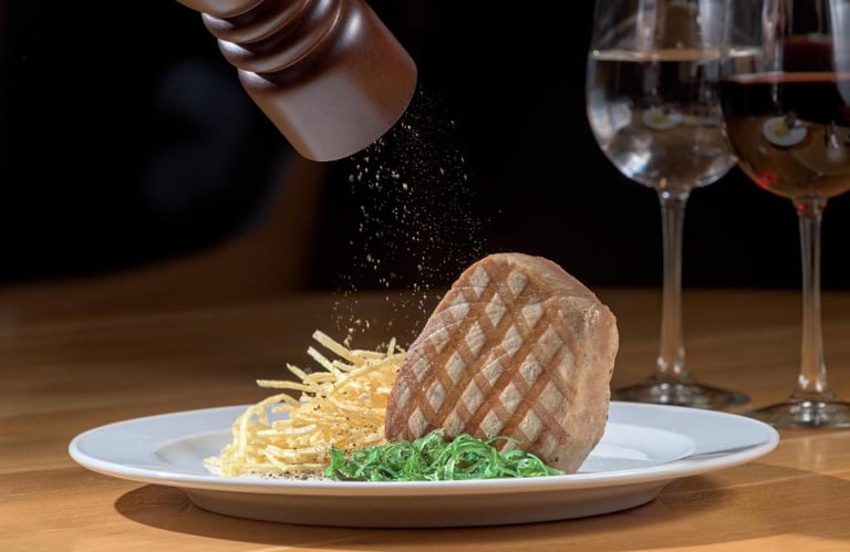 Fresh black pepper ground over a grilled steak fillet served with crispy shoestring fries.