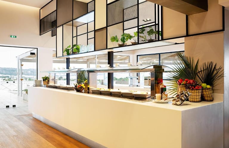 Modern hotel buffet breakfast area featuring fresh food displays and contemporary interior design.