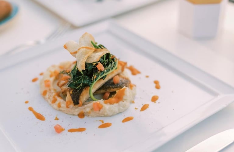 Gourmet pan-seared sea bass served over creamy puree with sauteed greens and parsnip chips.