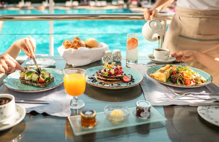 Gourmet breakfast with pancakes, toast, and orange juice served poolside at a luxury resort.