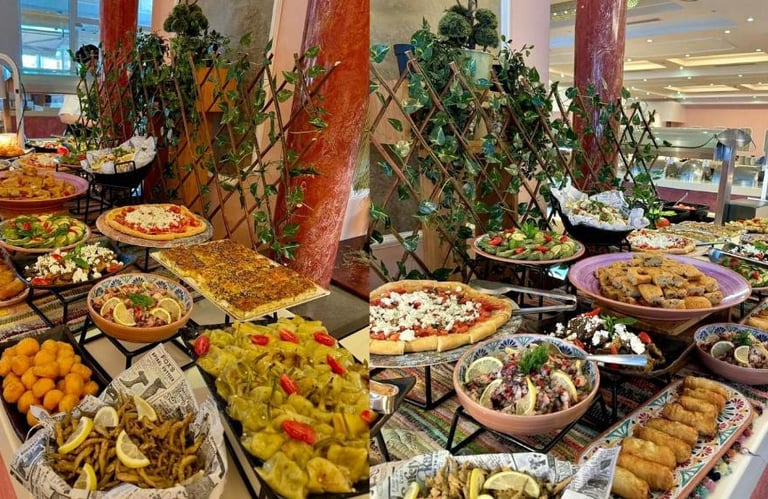 A gourmet hotel buffet spread featuring Mediterranean dishes like pizza, dolmas, salads, and fried seafood.