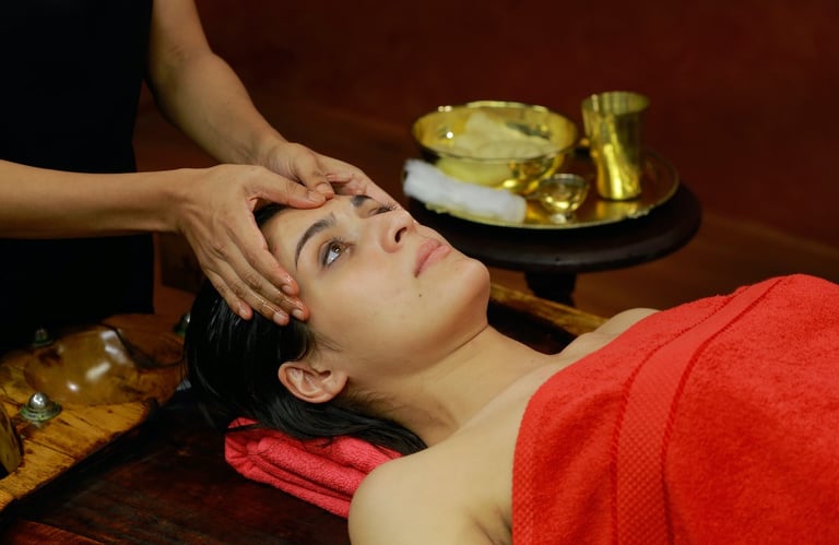 Woman receiving an Ayurvedic head massage in a serene setting, showcasing traditional healing practices of Kerala.