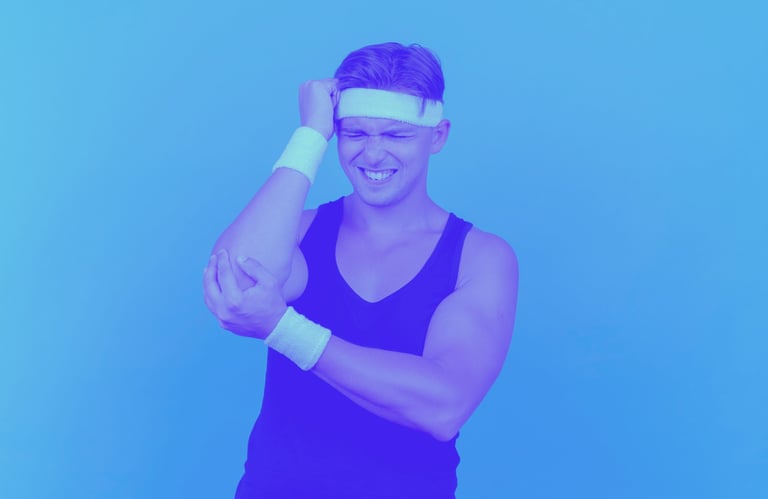A young man in tennis gear holding his elbow in pain.