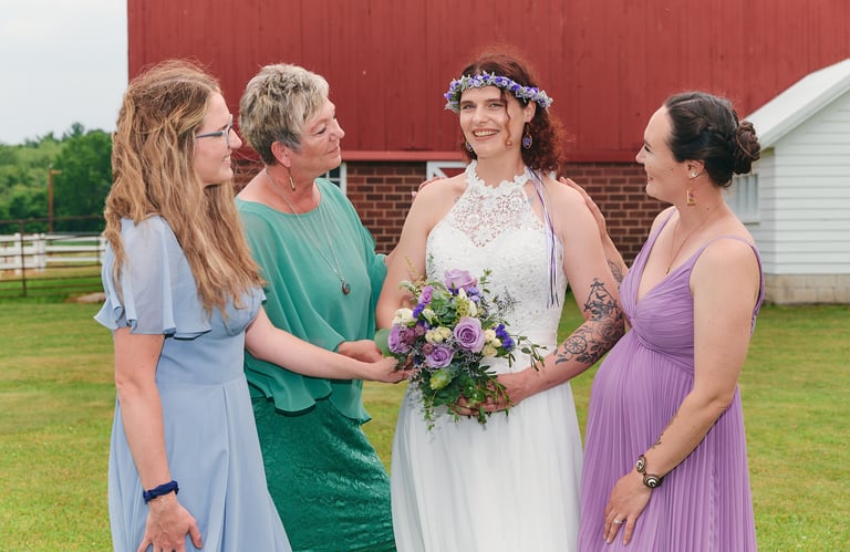 a bride and her bridesmaids are standing in front of a barn