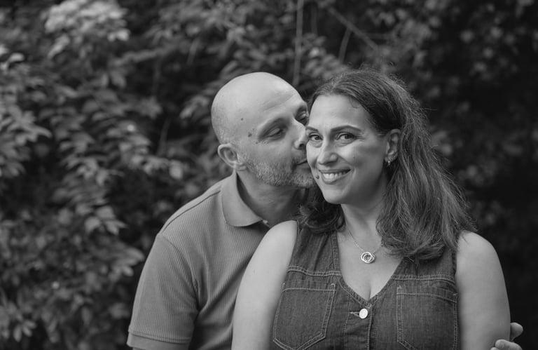 black and white image with man kissing woman on her cheek