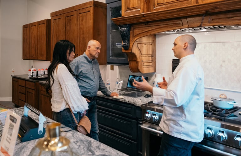 Chef Andrew in luxury kitchen appliance showroom talking with clients.