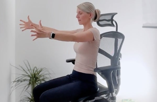 Office-Yoga-Übung im Bürostuhl – Arme nach vorne gestreckt zur Mobilisierung