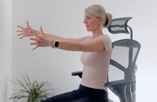 Office-Yoga-Übung im Bürostuhl – Arme nach vorne gestreckt zur Mobilisierung