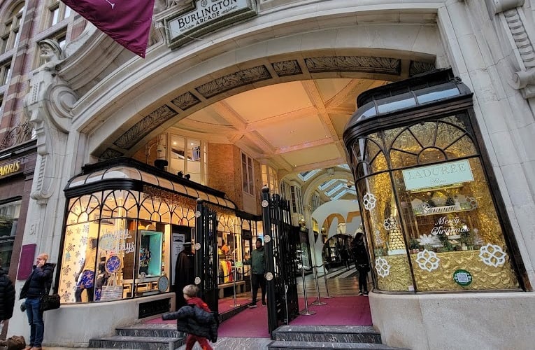 a woman walking down a sidewalk in front of a heritage building