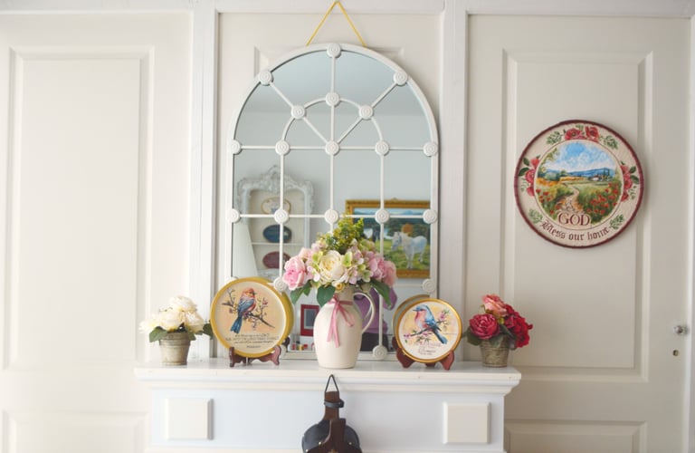 a vase with flowers on a mantle