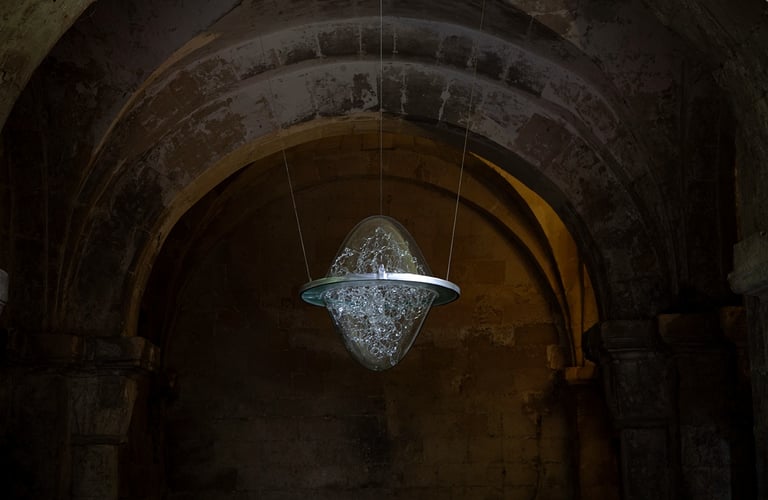a glass sculpture in the air suspended from the ceiling of the crypt