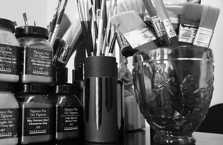 Détail atelier Stanislas Garaud, pinceaux, brosses, pots de pigments purs Sennelier sur cheminée marbre noir