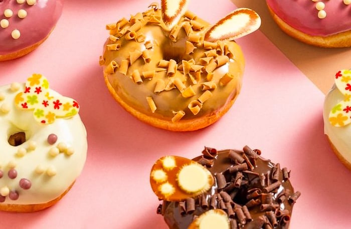 a variety of donuts and donuts on a pink background