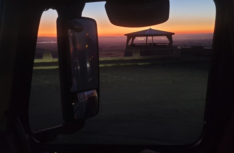 Impresionante vista del atardecer desde un camion, mostrando un pabellón y los vibrantes colores d