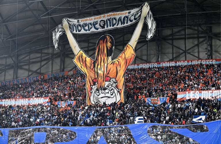 Blick ins Stadion von Olympique Marseille während eines Spiels, die Ultras im Heimblock mit Fahnen, Pyrotechnik und blau-weiß