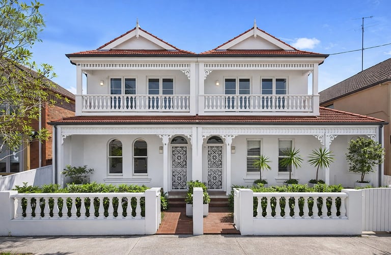 Design for a duplex development in Maroubra. Architecture features a light-colored facade, clean lines, landscaped frontages