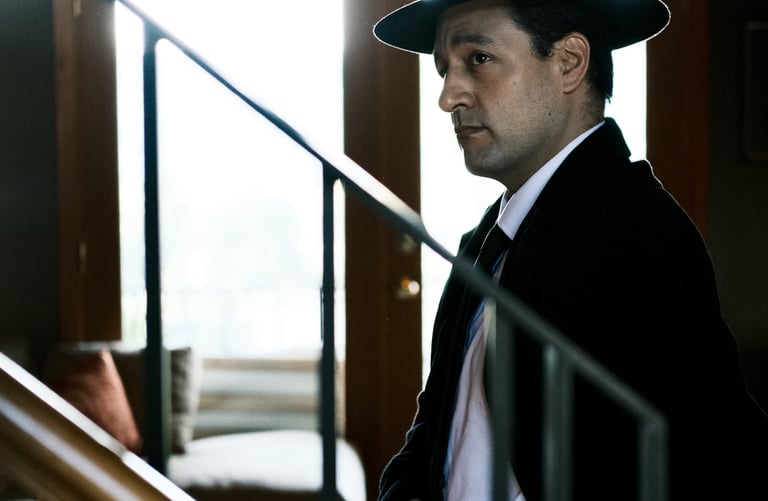 Production company shot of an actor in a suit and hat