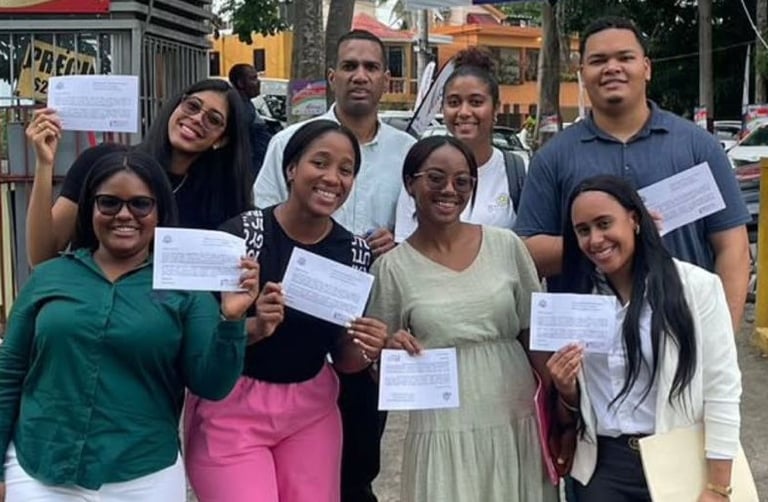 a group of people standing around a group of people holding up papers