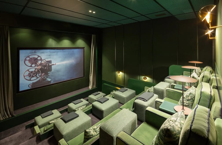 Cinema room at Villa La Gratitud with plush green armchairs