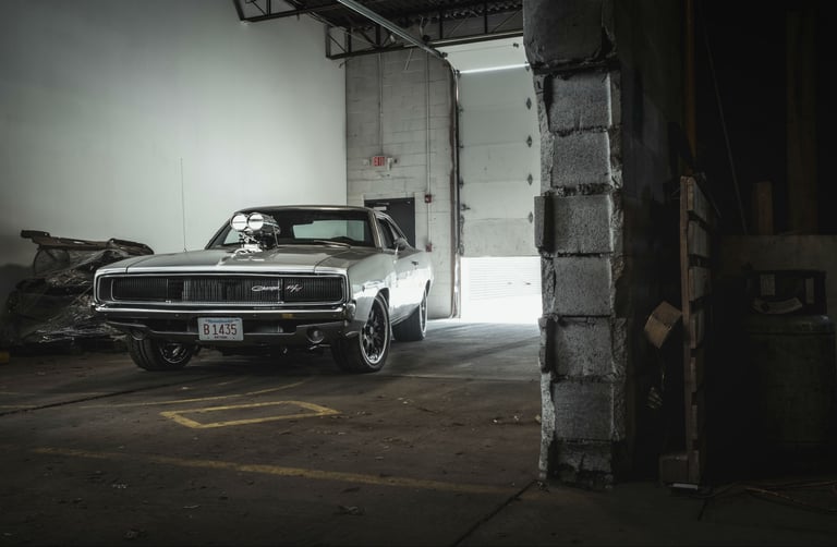Vintage silver 1968 Dodge Charger R/T muscle car with a supercharged engine in a garage.