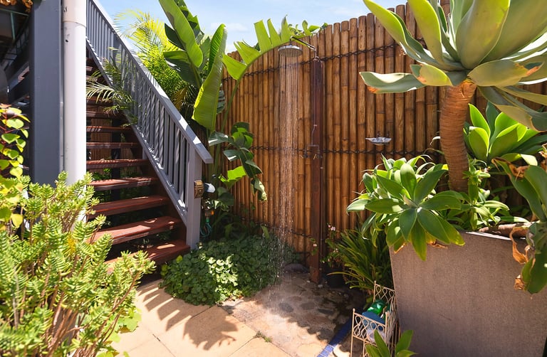 Outdoor shower and stairs leading to the accommodation at Marché Nude Stay.