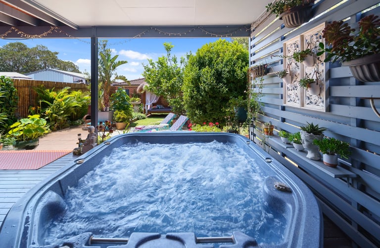 Outdoor spa at Marché Nude Stay surrounded by tropical greenery.