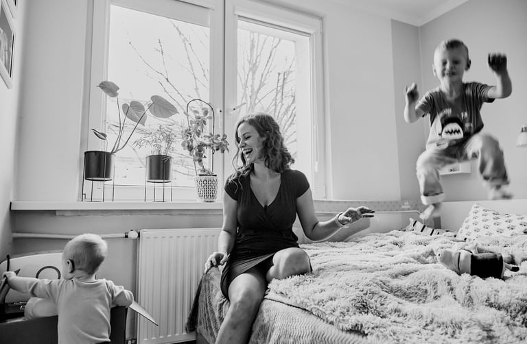 Czranobiała fotografia reportażowa przedstawiająca mamę z dwójką synów.