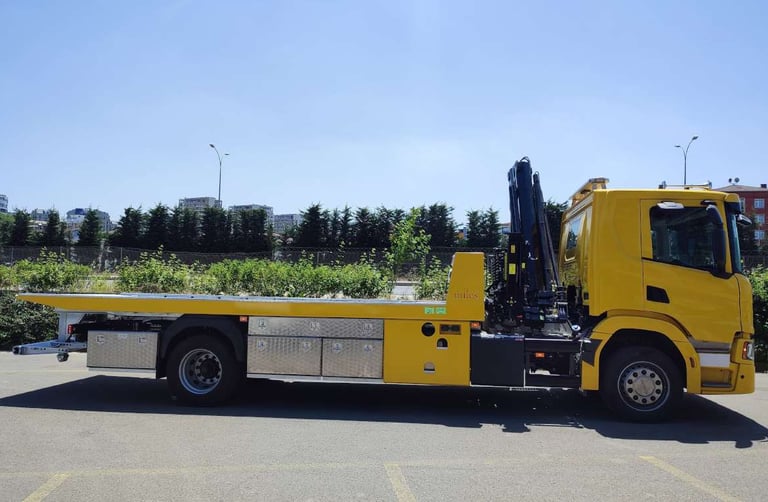 a yellow truck with a crane on it's back
