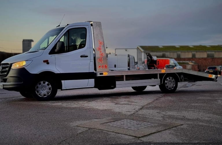 a white flat bed tow truck