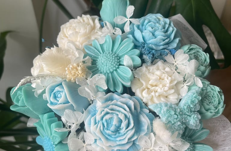 Bouquet de bougies artisanales bleues et blanches en cire végétale, façonnées comme des fleurs.