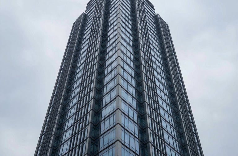 Low-angle architectural photography of a modern steel and glass skyscraper in Hyderabad, cool overcast daylight, deep blue and slate tones, sharp focus, 35mm