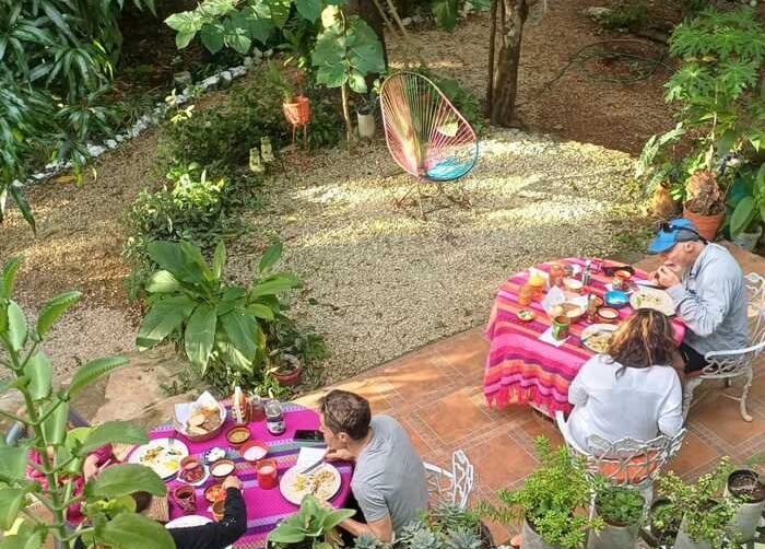 vista de personas desayunando en el jardín de mayan bungalow en chichen itza