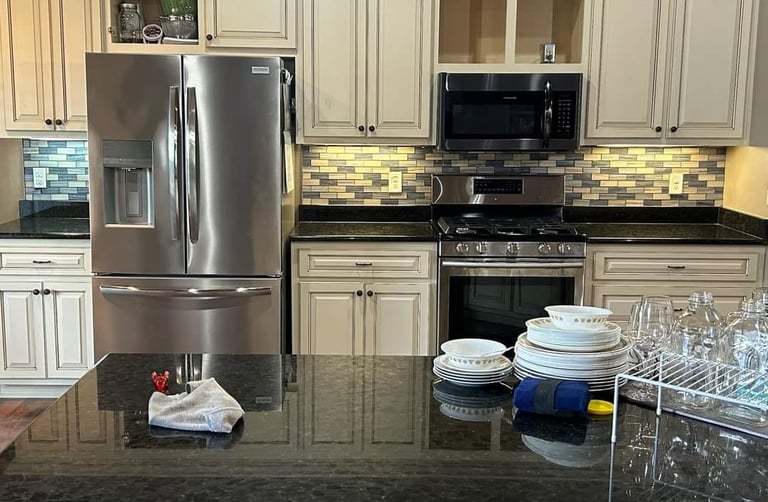 Kitchen remodel with cream cabinets and stainless steel appliances.