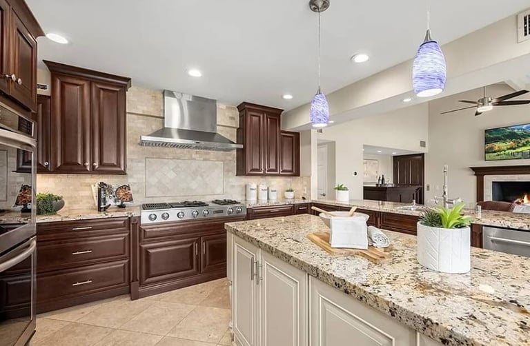Kitchen remodel with wood cabinets, granite countertops, and pendant lighting.