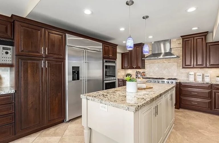 Kitchen remodel with wood cabinets, a center island, granite countertops, and appliances.